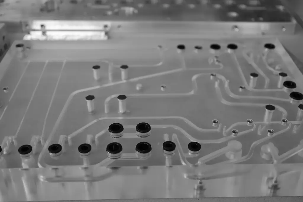 Präzisionsgefrästes Aluminiumbauteil mit Kanälen und eingesetzten Buchsen