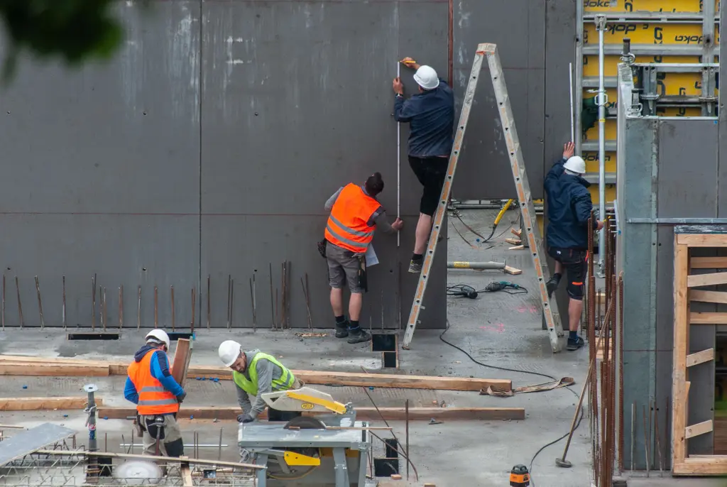 Bauarbeiter mit Schutzausrüstung errichten ein Betonbauwerk auf einer Baustelle